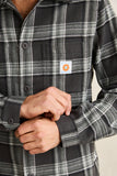 Person wearing a black and gray plaid shirt with a visible brand logo on the chest. Rhythm Alex Check LS Shirt - Forest