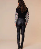 Woman wearing the classified 5 pocket coated jeans in black, showing the view from the back.