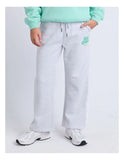 Person wearing gray sweatpants with a logo and a light green sweater on a white background. Eve Girl Sports Club Flare Trackpant - Snow