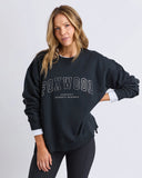 Woman wearing a black 'FOXWOOD' sweatshirt on a light gray background