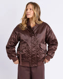 Woman wearing a brown jacket and pants on a white background