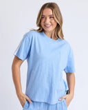 Woman wearing a light blue t-shirt and pants on a white background