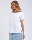 Woman wearing a white t-shirt and light blue jeans on a plain background
