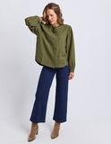 Woman wearing an olive green shirt and blue jeans on a white background Foxwood Eleanor Top - Winter Moss
