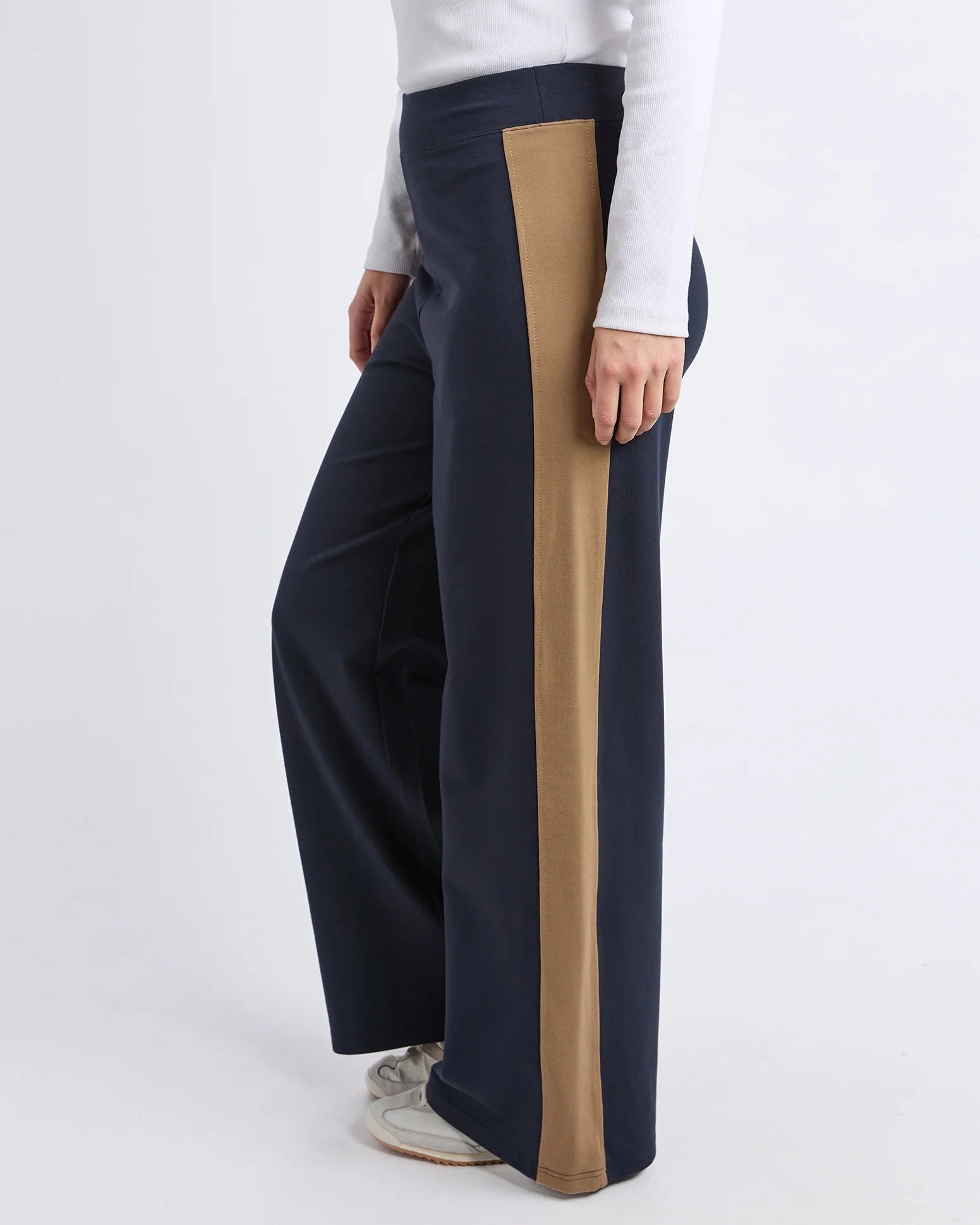Navy pants with a brown stripe worn by a person on a white background Foxwood Juno Pant - Ink