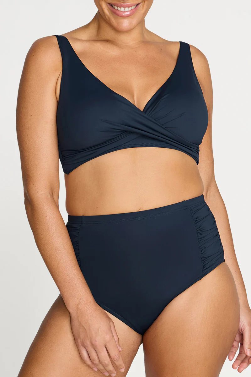 Woman wearing a navy blue bikini set on a white background