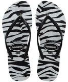 A pair of Havaianas Slim Animals Glitter Womens Jandals in black, featuring a tiger and leopard print design.