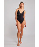 A model wearing a black one-piece swimsuit with a v-neck front and eyelet waist detail. Heaven Panther Coco One Piece - Black