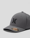 A dark gray structured baseball cap with a black embroidered Hurley logo on the front and a gold and black size sticker on the brim, set against a light gray background.