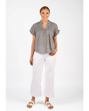 Front view of the Knewe Label Addison Top in Ink Gingham navy and white check, showcasing the elegant neckline and relaxed fit layout. Woman wearing a gray patterned shirt and white pants on a white background