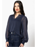 Woman wearing a dark blue textured blouse with a white background