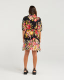 Woman wearing a floral dress on a white background NMBR Rose Marina Dress - Hibiscus