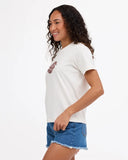 A woman wearing a white short-sleeve crewneck t-shirt with a small brown graphic on the left chest, paired with blue denim shorts, photographed against a solid white background.