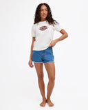 A woman modeling a white short-sleeve t-shirt with a brown graphic print on the chest, paired with blue denim shorts, against a plain white studio background.