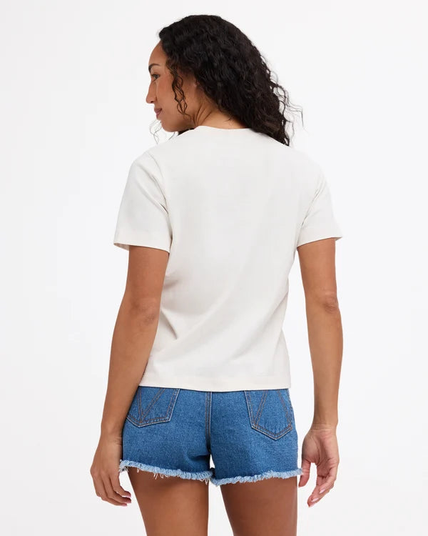 A woman shown from the back wearing a plain off-white short-sleeve t-shirt and blue denim shorts with a frayed hem, against a clean white background.