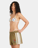 Woman wearing a floral bikini top and green shorts with white stripes on a white background RVCA Womens Mel G Elastic Waist Shorts - Olive