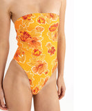 Close up shot of model wearing the Rhythm Ayla Floral Strapless One Piece - Orange Yellow strapless swimsuit with floral pattern on a white background
