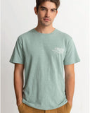 A male model wearing a green short sleeve t-shirt with a graphic print on the chest.
