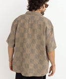 Man wearing a patterned shirt against a white background Rhythm Tanner Check SS Shirt - Tobacco