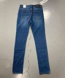 Blue jeans with a tag on a gray surface