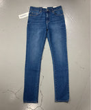 Blue jeans on a gray surface with a visible brand label.