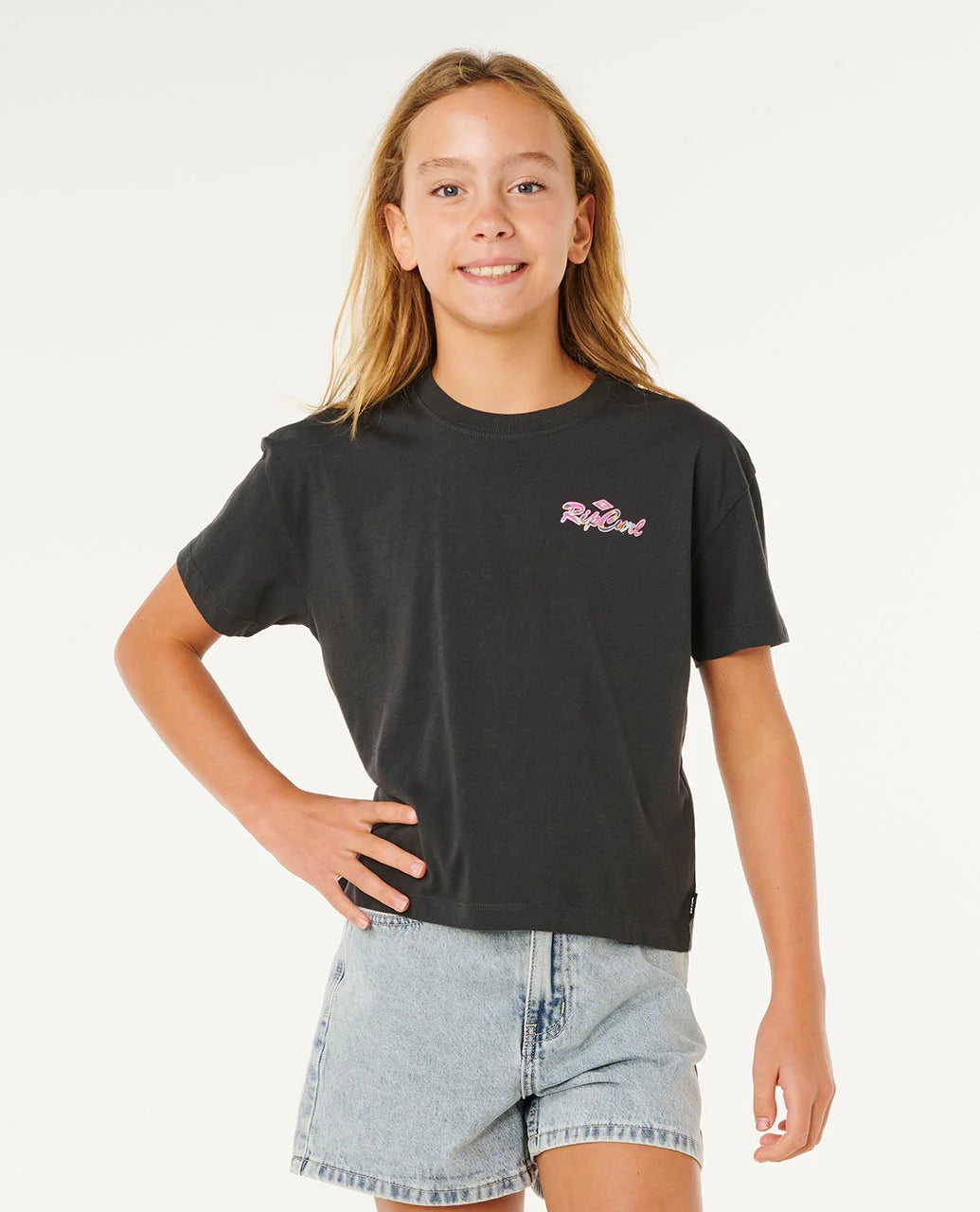 Young girl wearing a black t-shirt with a logo on a white background Rip Curl Girls Layday Crop tee - Washed Black
