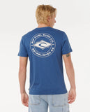 Person wearing a blue t-shirt with a logo on the back, standing against a white background
