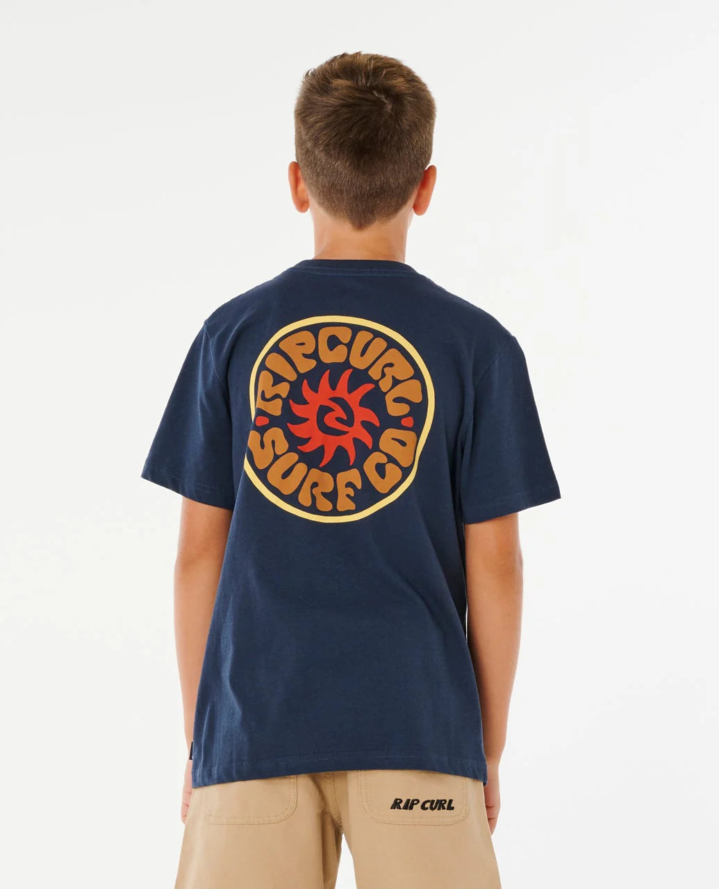 Person wearing a navy blue t-shirt with a logo on the back, standing against a white background