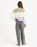Person wearing a color-blocked sweater and gray jeans on a white background. Roxy Dawn Patrol Mid Lava Denim Jeans - Lava