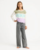 Girl wearing a Roxy shirt and jeans on a white background. Roxy Dawn Patrol Mid Lava Denim Jeans - Lava