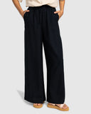 Person wearing black wide-leg pants on a light gray background