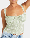 Light green floral top worn by a person on a white background