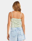 Woman wearing a floral tank top and denim shorts on a white background