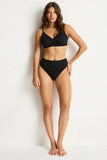 Woman wearing a black bikini against a white background
