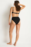 Woman wearing a black bikini against a white background