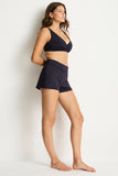 Woman wearing a navy blue bikini set on a white background