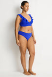 Woman wearing a blue bikini against a white background