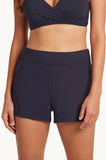 A model wearing a pair of high-waisted, solid navy blue athletic shorts, paired with a matching navy sports bra against a clean white background.