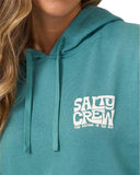 A close-up of a person wearing a teal hoodie with a white 'SALTY CREW' graphic on the chest. The image is cropped to show the model's chin, neck, hair, and the hoodie details. Salty Crew Womens Freestyle Hoodie - Teal