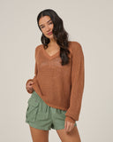 Front view of the a woman wearing the Salty Crew Womens Surge Sweater - Mocha with green shorts on a white background.