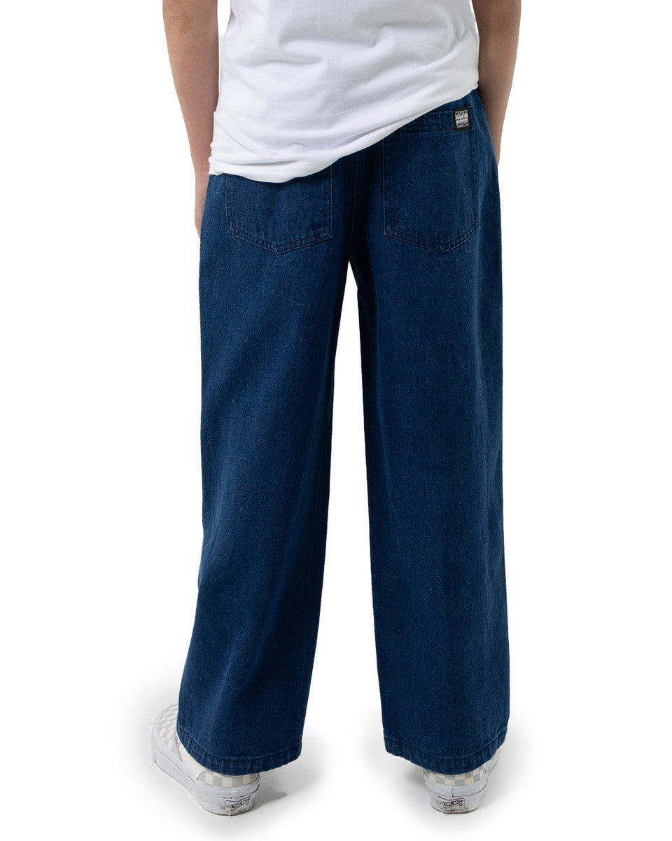 Person wearing blue wide-leg pants and a white shirt on a white background Santa Cruz Multi Cruz Stack Alien Boys Jeans - Stone Wash Indigo