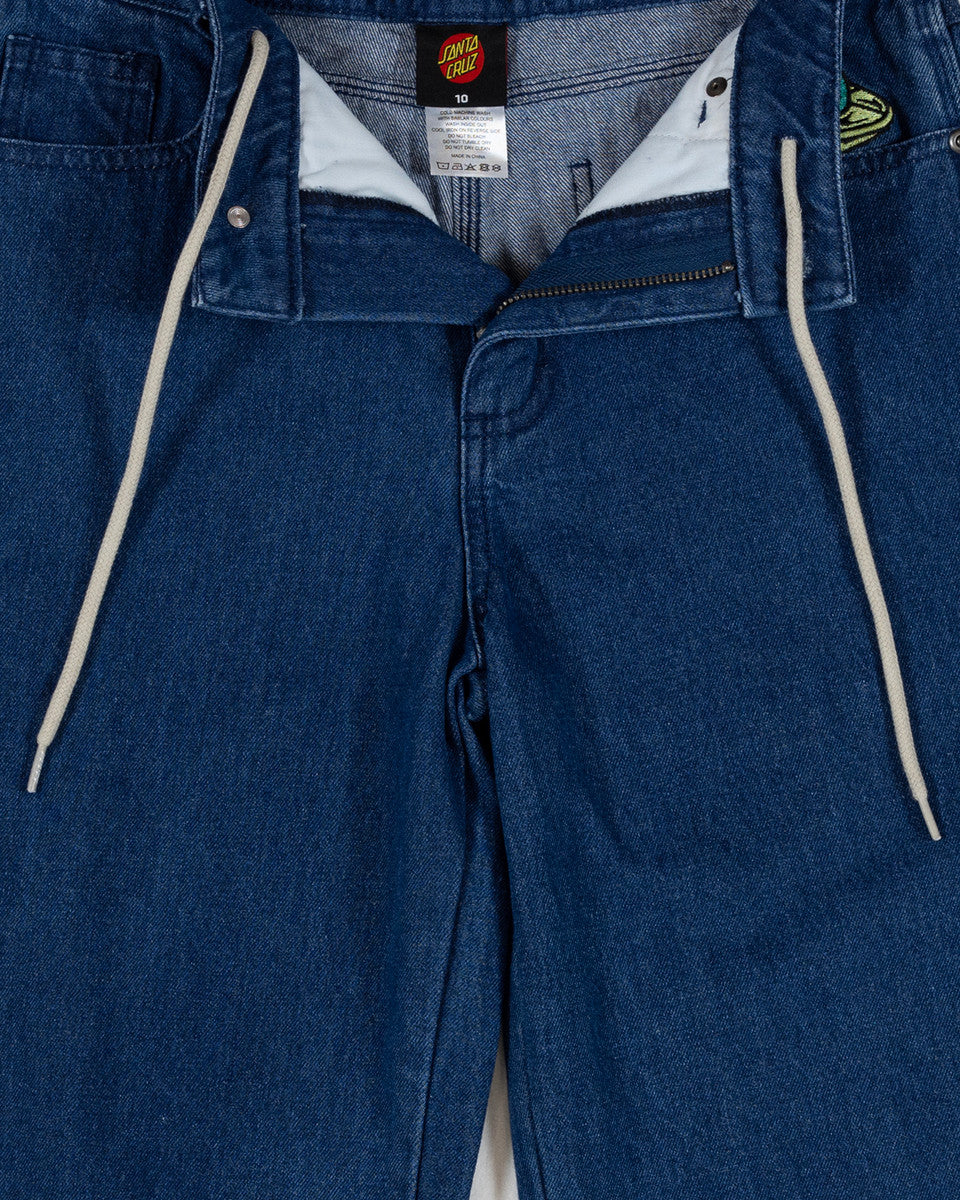 Close-up of blue jeans with a brand label visible. Santa Cruz Multi Cruz Stack Alien Boys Jeans - Stone Wash Indigo