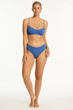 Woman wearing a blue bikini set on a white background