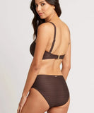 A woman modeling a dark brown ribbed bikini set, shown from a three-quarters back view against a light gray studio background.