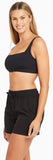 Woman wearing a black sports bra and shorts on a white background