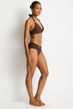 Woman wearing a brown bikini against a white background