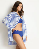 Woman wearing a blue and white striped cover-up over a blue bikini set on a plain background Sea Level Vacay Cruise Shirt - Blue