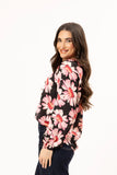Woman wearing a floral blouse with pink flowers on a white background Seeking Lola Connected Blouse - Bold Rosette