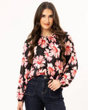 Woman wearing a black floral blouse with pink flowers on a white background Seeking Lola Connected Blouse - Bold Rosette