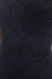 Close-up of a dark navy or black textured fabric with an allover geometric pattern.
